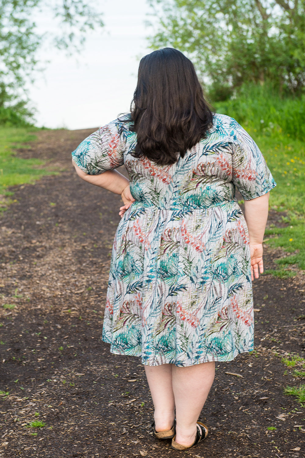 Back view of Emmeline in plus size featuring elbow-length sleeves and knee-length skirt. 