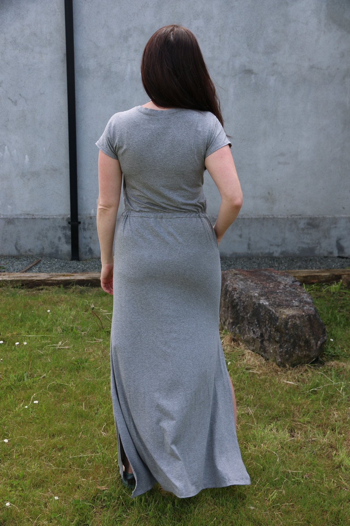 Back view of the Helen dress in misses. Features a maxi-length skirt with a split hem. 