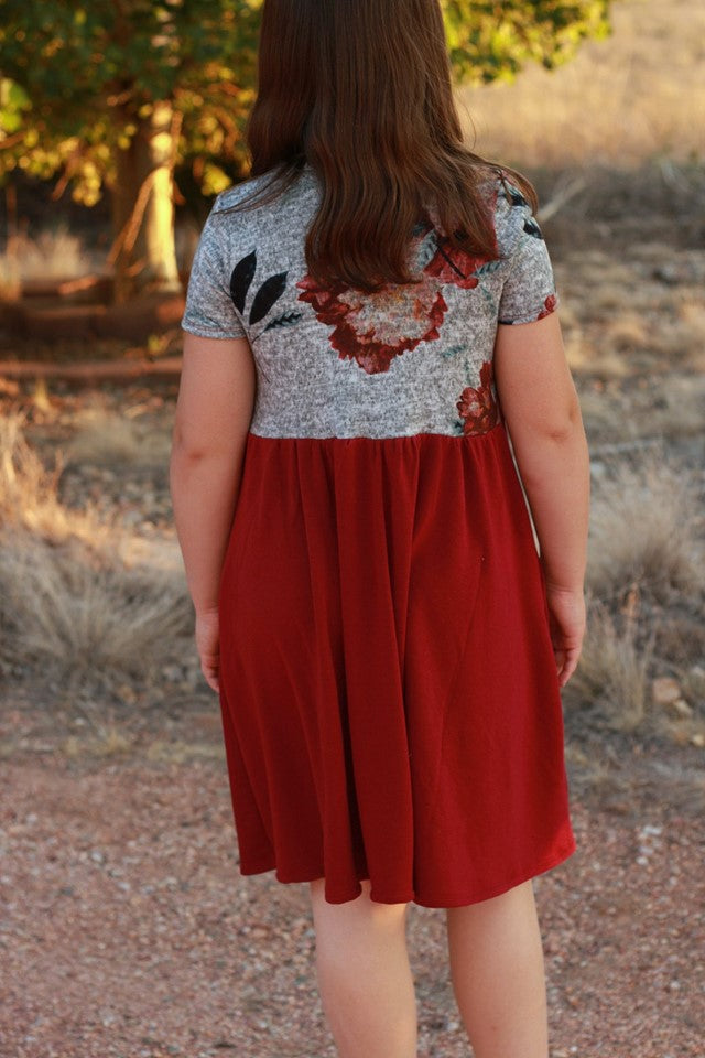 Back view of a young girl with a short sleeve, knee length Samantha dress. 
