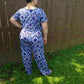 Back view of a plus size Stevie jumpsuit in a colorful blue pattern. Features short sleeves and wide leg pattern options. 